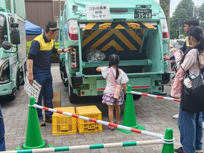 ごみ袋投げ入れ体験でごみをパッカー車に投げ入れているお子様の様子
