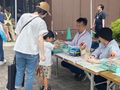 総合案内所で花の種子などをお子様に渡している様子