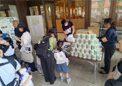 古紙のブースで説明を聞いている親子の様子