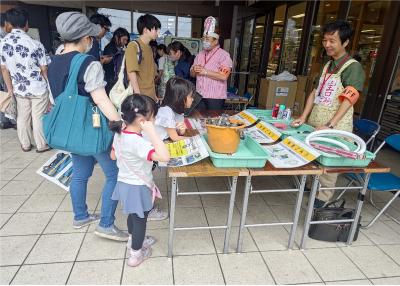 有害ごみのブースで説明を聞いている親子の様子