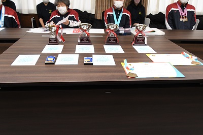 机に並べられたトロフィーや賞状の写真