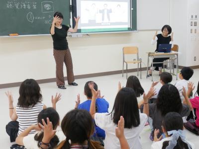 拍手の手話を練習中の写真