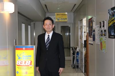 調布警察署長が調布FMの前で写真撮影する様子